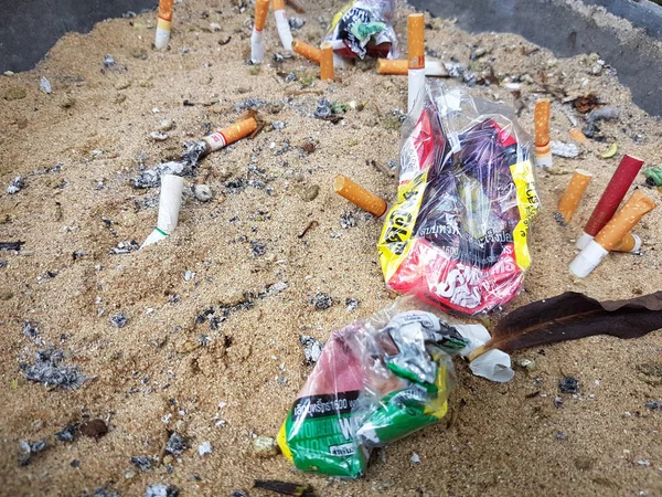 Chiang Rai, Tayland - 25 Kasım: Kirli kül tablası ile kum ve buruşuk sigaralık üzerinde 25 Kasım 2016 yılında Chiang rai, Tayland, kullanılan sigara izmariti