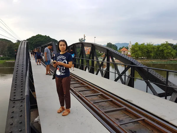 KANCHANABURI, TAILANDIA - 26 DE NOVIEMBRE: Mujer asiática no identificada de pie en el puente sobre el río Kwai el 26 de noviembre de 2016 en Kanchanaburi, Tailandia — Foto de Stock