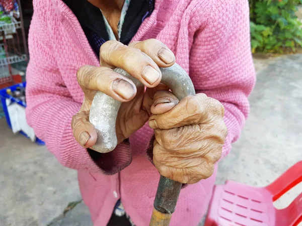 Primer plano mano de un viejo asiático mujer pensionista en un caminar palo o un bastón — Foto de Stock