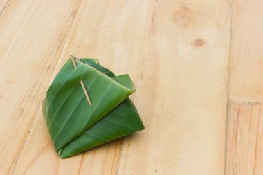 Tay gıda veya ahşap zemin üzerine Muz Yaprak Sarma tatlı. Boşaltmak.