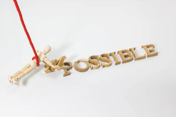 Omzetten in het woord niet onmogelijk mogelijk met houten pop opknoping op het rood touw — Stockfoto