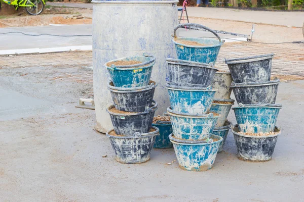 Sand in many buckets prepared for mixing cement or concrete in construction site, horizontal photo. — Stock Photo, Image