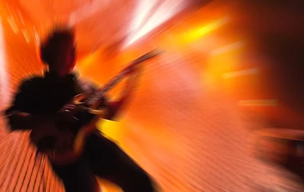 Defocused blurred guitar player on stage of rock concert with speed motion blur filter. — Stock Photo, Image