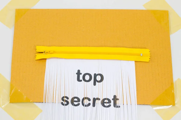 Streng geheim, zerstörendes Blatt Papier mit gelbem Reißverschluss als Schredder. — Stockfoto