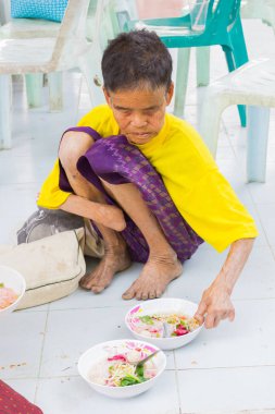 CHIANG RAI, THAILAND - FEBRUARY 19 : Unidentified old asian woman suffering from leprosy eating food on February 19, 2016 in Chiang rai, Thailand. clipart