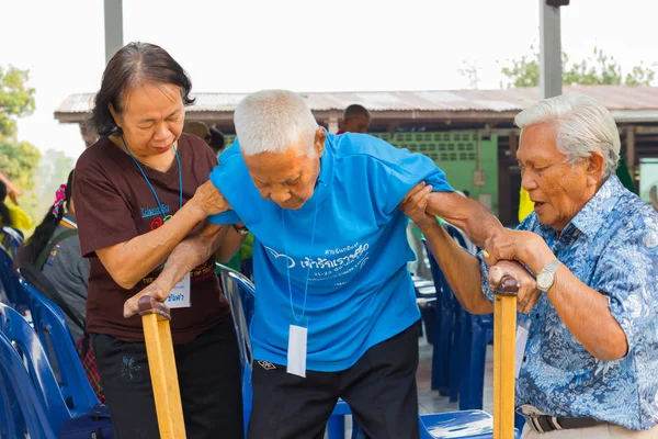 CHIANG RAI, TAILANDIA - 20 DE FEBRERO: pareja no identificada ayudando a un anciano asiático con lepra el 20 de febrero de 2016 en Chiang rai, Tailandia . — Foto de Stock