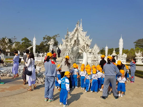 Chiang Rai, Thajsko - březen 1: skupina neznámých asijských studentů s žlutá čepice na exkurzi v chrámu Wat Rong Khun děje 1. března 2017 v Chiang rai, Thajsko — Stock fotografie