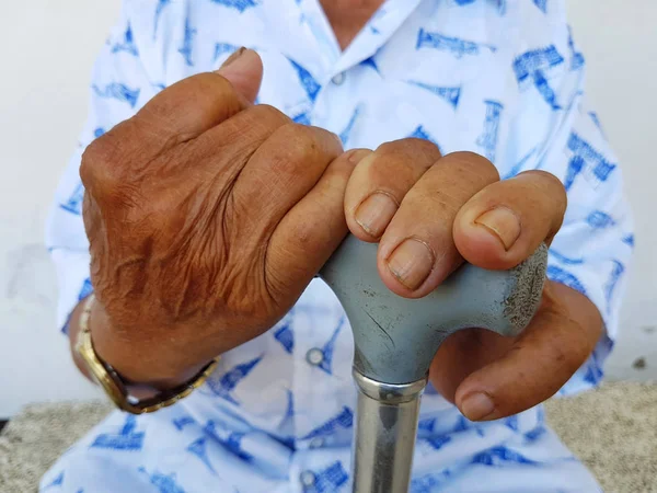 Closeup hand of old asian male with a watch holding a cane — Stock Photo, Image