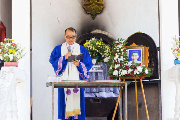 ЧАЙАНГ-РАЙ, ТАЙЛАНД - 19 апреля 2017 года в Чианграе, Таиланд, неопознанный азиатский пастор в синей форме, проповедующий на тайских традиционных христианских похоронах
.