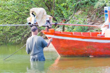 : Phetchaburi, Thailand - 7 Nisan: kimliği belirsiz Asyalı adam 7 Nisan 2017 yılında: Phetchaburi, Thailand üzerinde turuncu teknesini deniz üzerinde beyaz renk ile boyama.