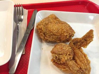 Bıçak ve çatal Restaurant ile beyaz çanak üzerinde taze kızarmış tavuk.