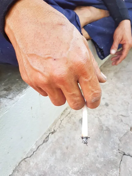 Asiático hombre de la mano celebración de quema tradicional cigarrillo en la mano — Foto de Stock