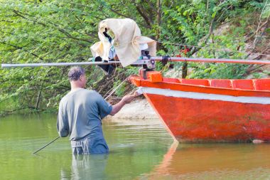 : Phetchaburi, Thailand - 7 Nisan: tanımlanamayan Tay balıkçı tarihinde 7 Nisan 2017: Phetchaburi, Thailand içinde deniz üzerinde turuncu teknesini sabitleme.