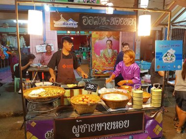 Kamphaeng Phet, Tayland - 6 Mayıs: Tay geleneksel giysi satan ile kimliği belirsiz Asyalı adam üzerinde 6 Mayıs 2017 yılında Kamphaeng Phet, Tayland Nakhon Chum sokak pazarında istiridye omlet kızarmış.