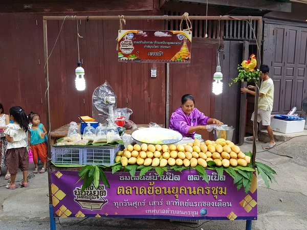 КАМФАЕНГ-ФЕТ, ТАЙЛАНД - 6 мая 2017 года неопознанная азиатская женщина с традиционной тайской одеждой, продающая манго и сладкий липкий рис на уличном рынке Накхон-Чум 6 мая 2017 года в Кампхенг-Пхете, Таиланд . — стоковое фото