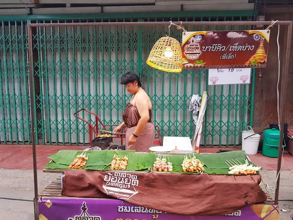 KAMPHAENG PHET, THAILAND - 6 de maio: mulher asiática não identificada com roupas tradicionais tailandesas vendendo churrasco ou churrasco no mercado de rua Nakhon Chum em 6 de maio de 2017 em Kamphaeng Phet, Tailândia . — Fotografia de Stock