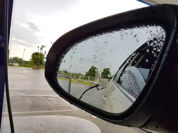 Miroir latéral réfléchissant la buse de carburant dans la journée de pluie — Photo