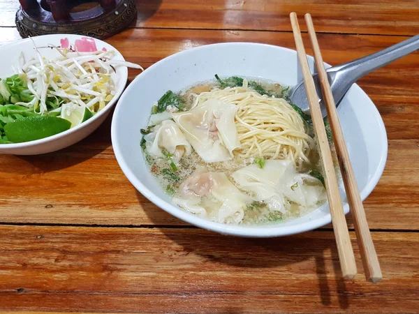 麺と餃子 chipsticks と木製の背景にスプーンとスープ — ストック写真