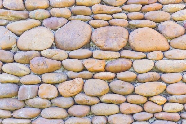 River pebbles round stone wall background — Stock Photo, Image