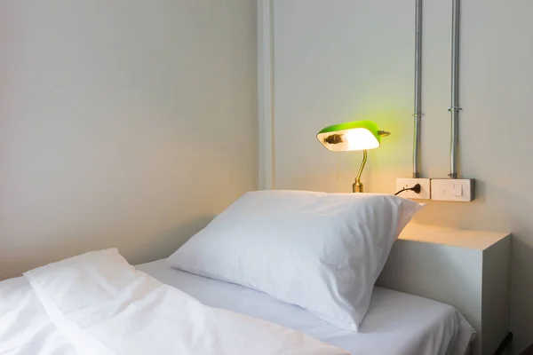 Крупним планом біла спальня і подушка з зеленою лампою — стокове фото