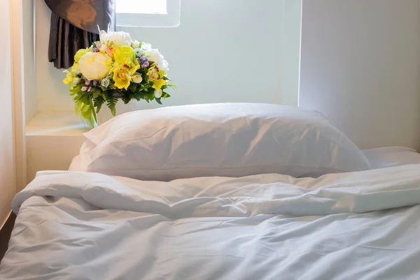 Крупним планом біла спальня і подушка з жовтими квітами біля вікна — стокове фото
