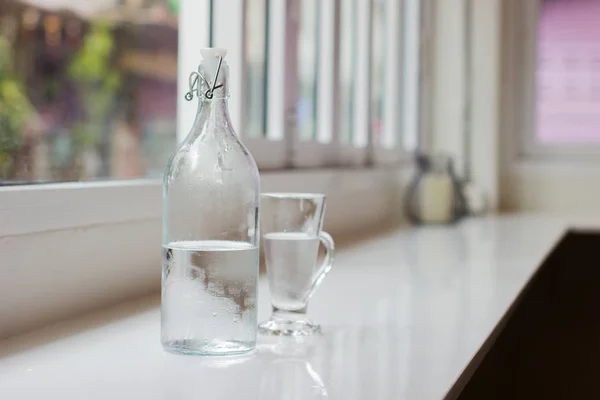 Szklanka wody z butelki na stole. Płytkiej głębi ostrości. Poziome zdjęcie — Zdjęcie stockowe