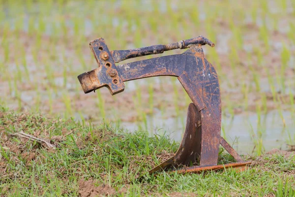 Arado oxidado manejar hierro en el campo de arroz —  Fotos de Stock