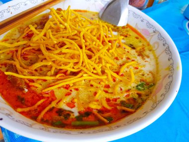 Khao Soi, Kuzey Tayland tarzı Curried şehriye çorbası yemek çubukları ve mavi masa kaşık ile