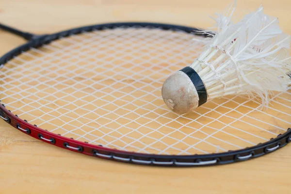 Close-up old shuttlecock on badminton racket after being used for hard practice — Stock Photo, Image