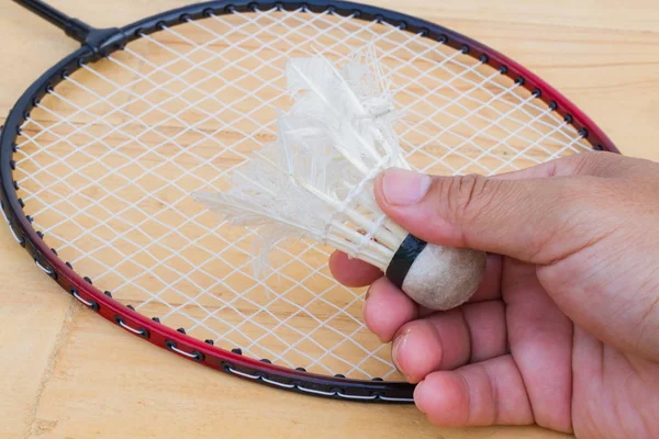 Close-up hand met oude shuttle op badminton racket — Stockfoto