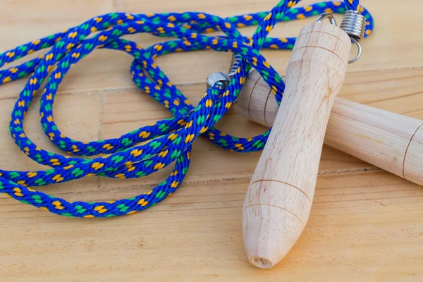 Cuerda de salto azul con mango de madera en bakcground de madera —  Fotos de Stock