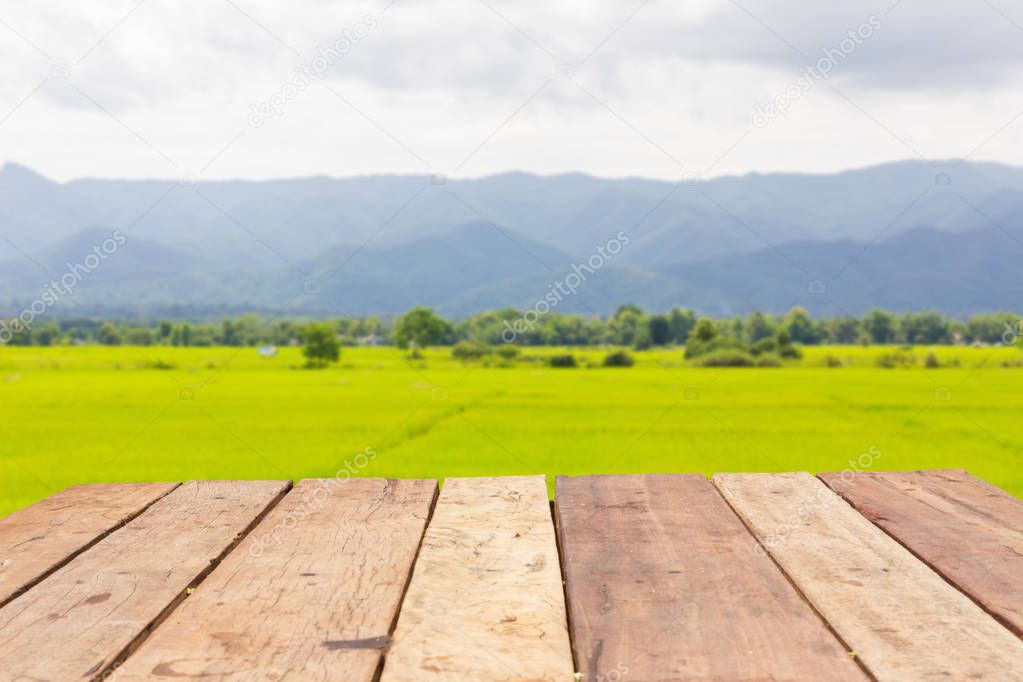 perspective wooden board empty table in front of blurred background of rice field landscape, can be used for display or montage your products. Mock up for displaying product.