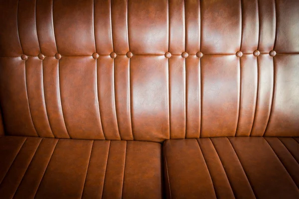 Дорога коричнева шкіряна текстура дивана крупним планом, вінтажний фон — стокове фото