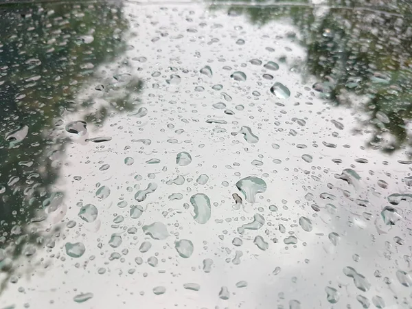 Дождь падает перед окном автомобиля с отражением — стоковое фото