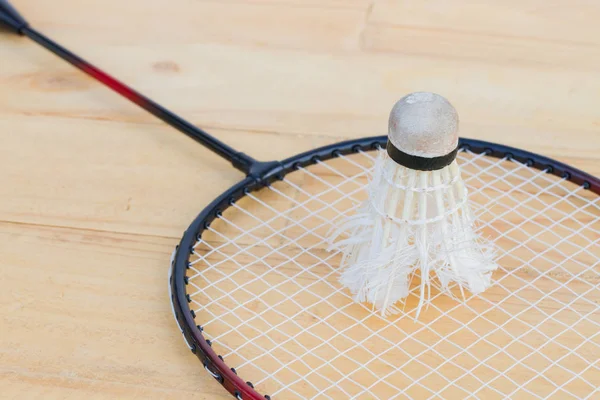 Close-up vieille navette sur raquette de badminton sur backgroun en bois — Photo