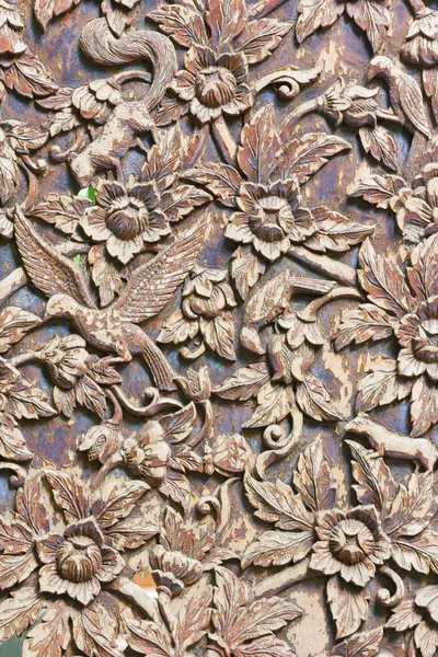 Carved animals and flowers on the wood background, vertical phot