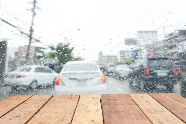 Vieille table en bois rétro vide devant une pluie trouble sur le pare-brise d'un véhicule dans la rue — Photo