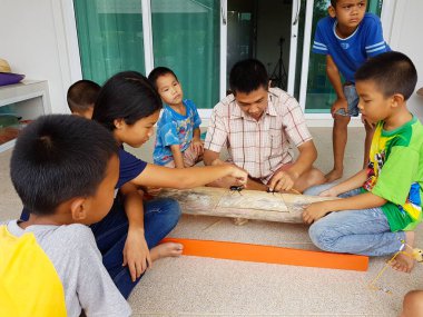 Chiang Rai, Tayland - 9 Eylül: gergedan böceği Chiang rai, Tayland 9 Eylül 2017 üzerinde mücadele izlerken kimliği belirsiz Asyalı çocuk.