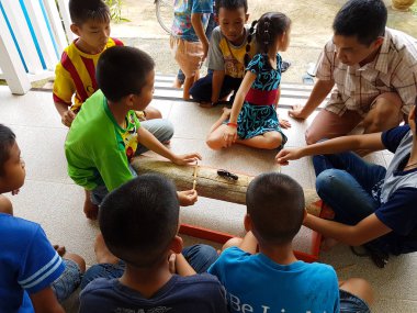 Chiang Rai, Tayland - 9 Eylül: gergedan böceği Chiang rai, Tayland 9 Eylül 2017 üzerinde mücadele izlerken kimliği belirsiz Asyalı çocuk.