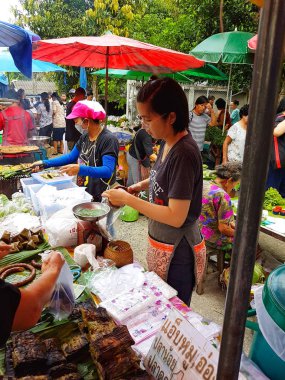 Chiang Mai, Tayland - 29 Eylül: Kimliği belirsiz Asyalı kadın ile 29 Eylül 2017 Chiang Mai, Tayland tarihinde akşamları semt pazarı gıda satan gözlük.