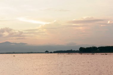 Tayland bulutlu gökyüzü ile sakin göl üzerinde güzel gün batımı