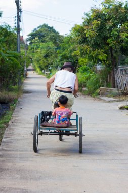 Chiang Rai, Tayland - 5 Kasım: üç tekerlekli bisiklet üstünde belgili tanımlık yol ile birlikte torunu arkada 5 Kasım 2017 üzerinde Chiang rai, Tayland tanımlanamayan Engelli Asya eski kişini. 