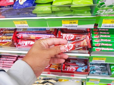 Chiang Rai, Tayland - 6 Kasım: el Asyalı adamın Kitkat aperatif Chiang rai, Tayland 6 Kasım 2017 kolaylık mağaza rafındaki holding.