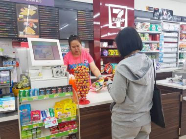 Chiang Rai, Tayland - 6 Kasım: kimliği belirsiz Asyalı kadın bir 7-Eleven kolaylık mağazasında kasiyer sayacı, Chiang rai, Tayland 6 Kasım 2017 ödemek için bekliyor.