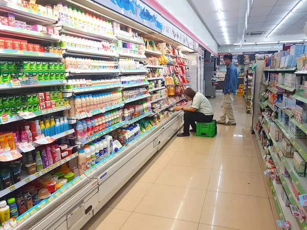 清莱, 泰国-11月6日: 身份不明的便利店工作人员在2017年11月6日在泰国清莱货架上检查乳制品. — 图库照片