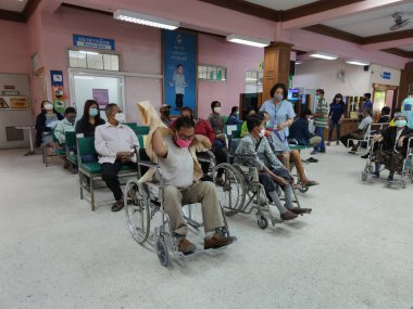 CHIANG RAI, THAILAND - 23 Mart 2020 'de Chiang Rai, Tayland' da Covid-19 virüsünün yayılması sırasında Phan hastanesinde tekerlekli sandalyede oturan kimliği belirsiz Asyalı erkek hasta.