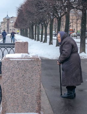 Rusya, St. Petersburg. 9 Şubat 2020. Yaşlı kadın ayağa kalkıyor ve yürümeyi bekliyor..