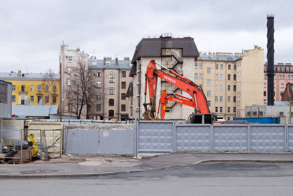 St. Petersburg, Russia - February 23, 2020. Exavator, heavy construction equipment on the demolition of the dilapidated building of the old housing stock and clearing of the vacant space.