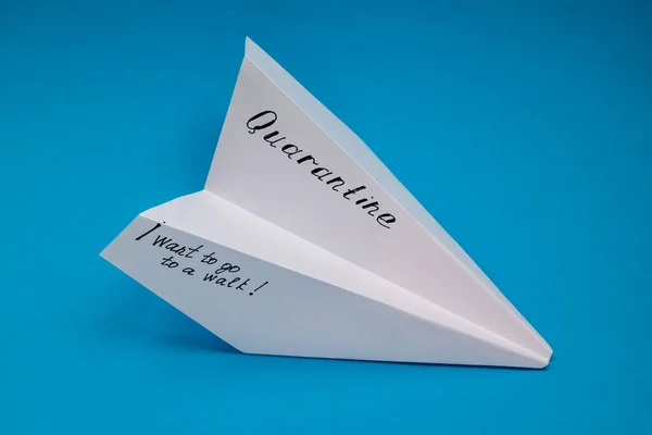 Papírové letadlo s ručně psanými slovy karanténa a fráze Chci jít na procházku. — Stock fotografie