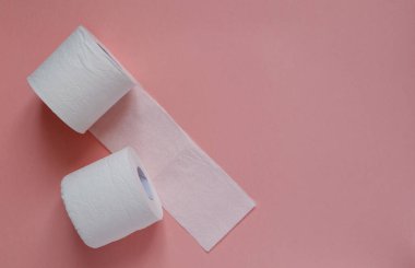 Pembe arka planda bir sürü beyaz tuvalet kağıdı var. Panik, covid-19 konsepti.